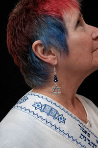 Lynne wearing Star of David earrings with dark blue glass beads