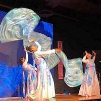 Worshipper using the Living Waters silk flag set in flowing shades of blue, turquoise, and aqua