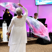 Lora worshipping with a Secret Place silk worship flag